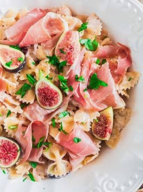 The best easy tortellini salad with fresh sliced figs, crispy prosciutto, and chopped walnuts in a ceramic bowl.