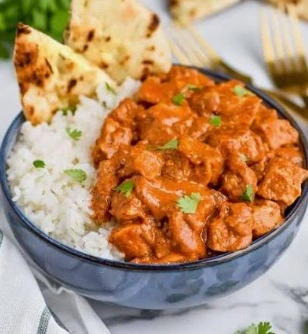 The best easy butter chicken with creamy orange tomato sauce served in a copper bowl with basmati rice.